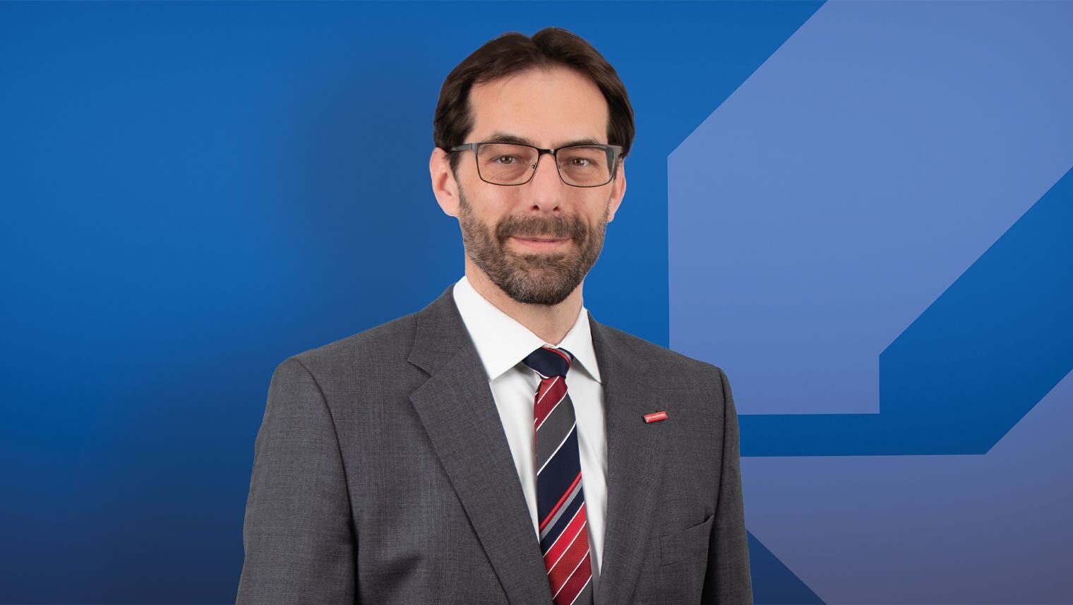 Das Portrait eines Mannes. Er lächelt ein wenig. 