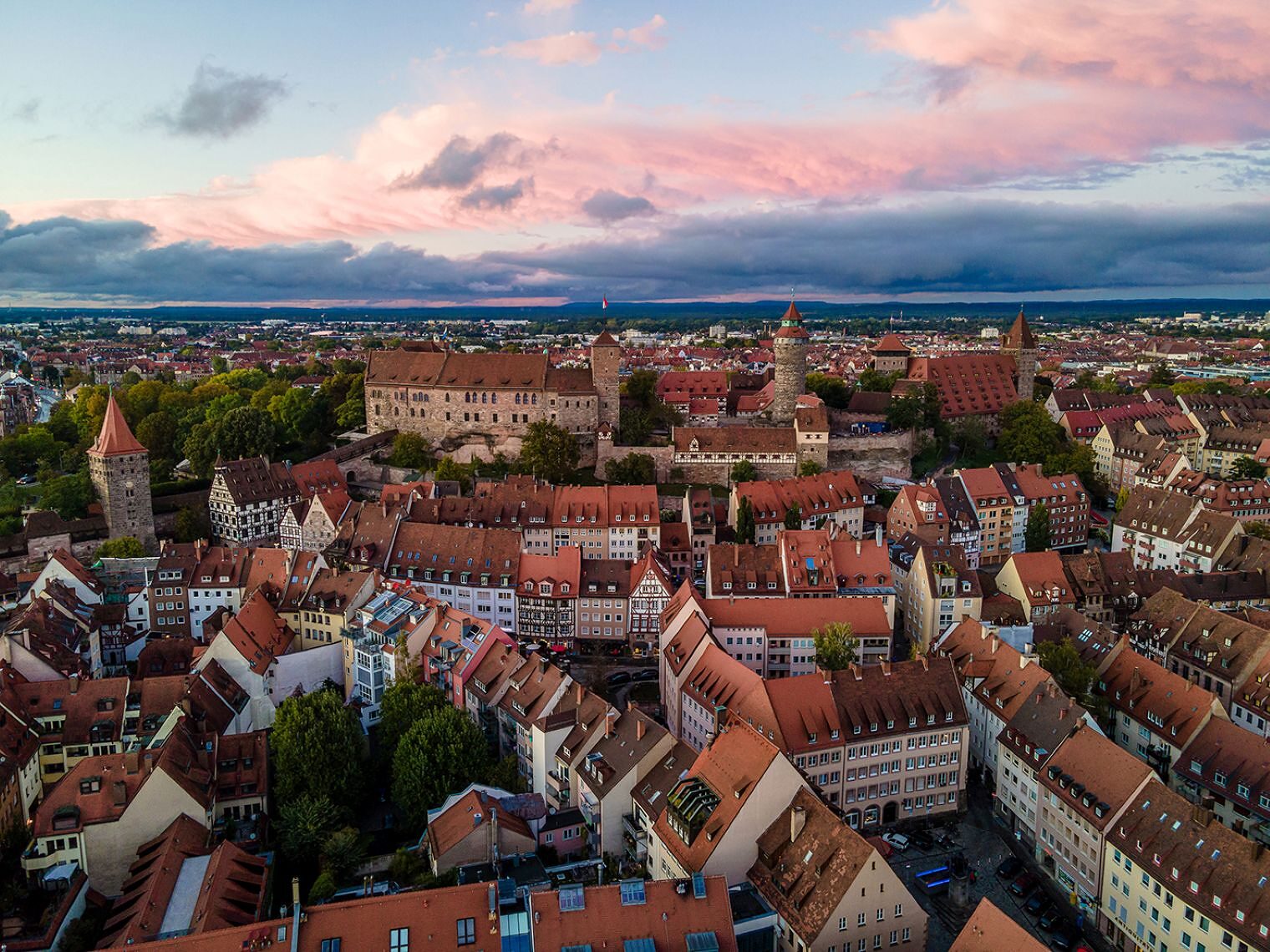 Man sieht die Altstadt von Nürnberg mit der Kaiserburg von oben bei Sonnenuntergang.