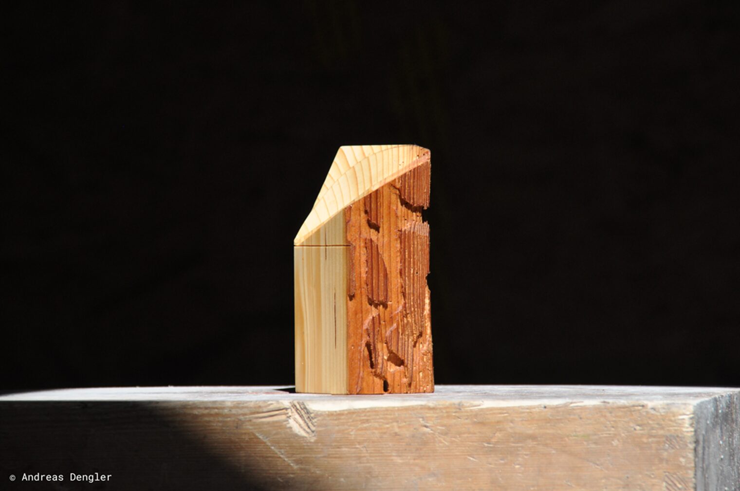 Ein Stück Holz auf einem Holzbalken