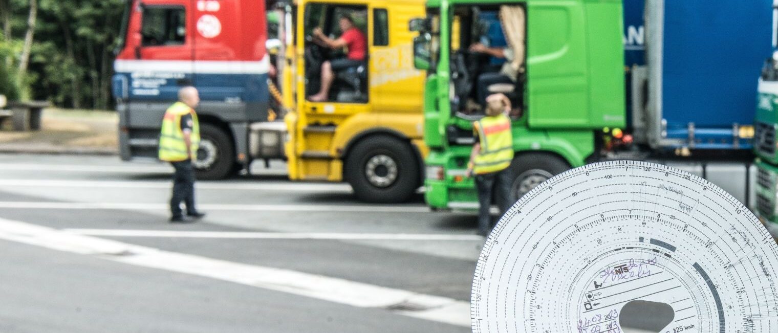 Parkende Lkws mit offener Tür. Innen sitzen Fahrer. Polizisten sprechen mit ihnen. 