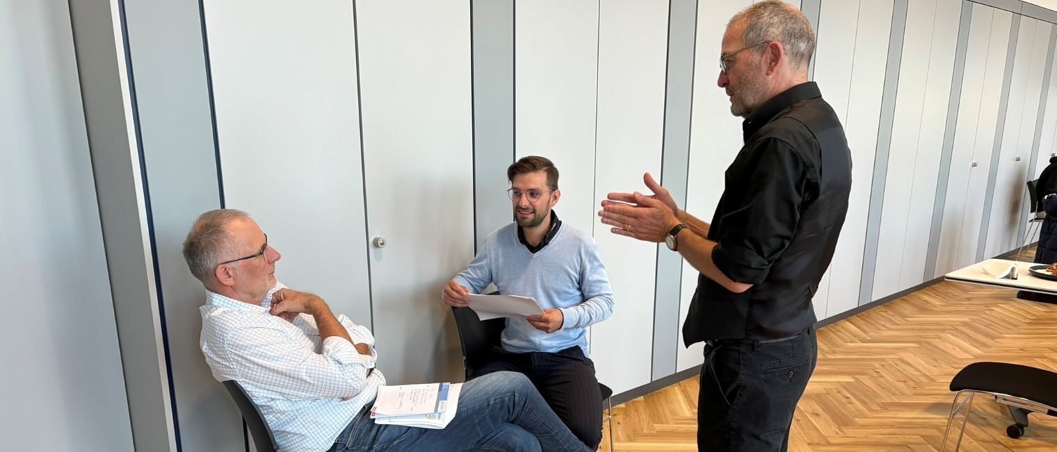 Drei Männer diskutieren miteinander