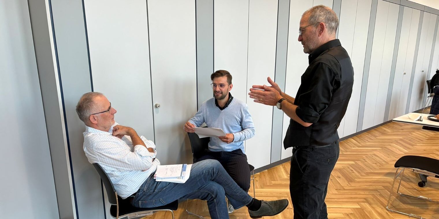 Drei Männer diskutieren miteinander
